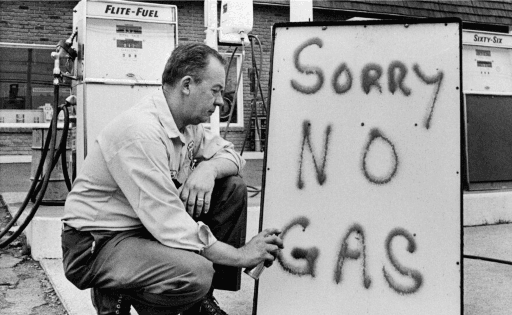 Gas station owner places a sign out side stating they are out of gas in 1973.